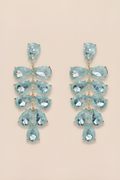 Pair of turquoise teardrop earrings on a beige background