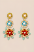 Colorful floral earrings with gold accents on a beige background