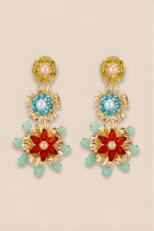 Colorful floral earrings with gold accents on a beige background