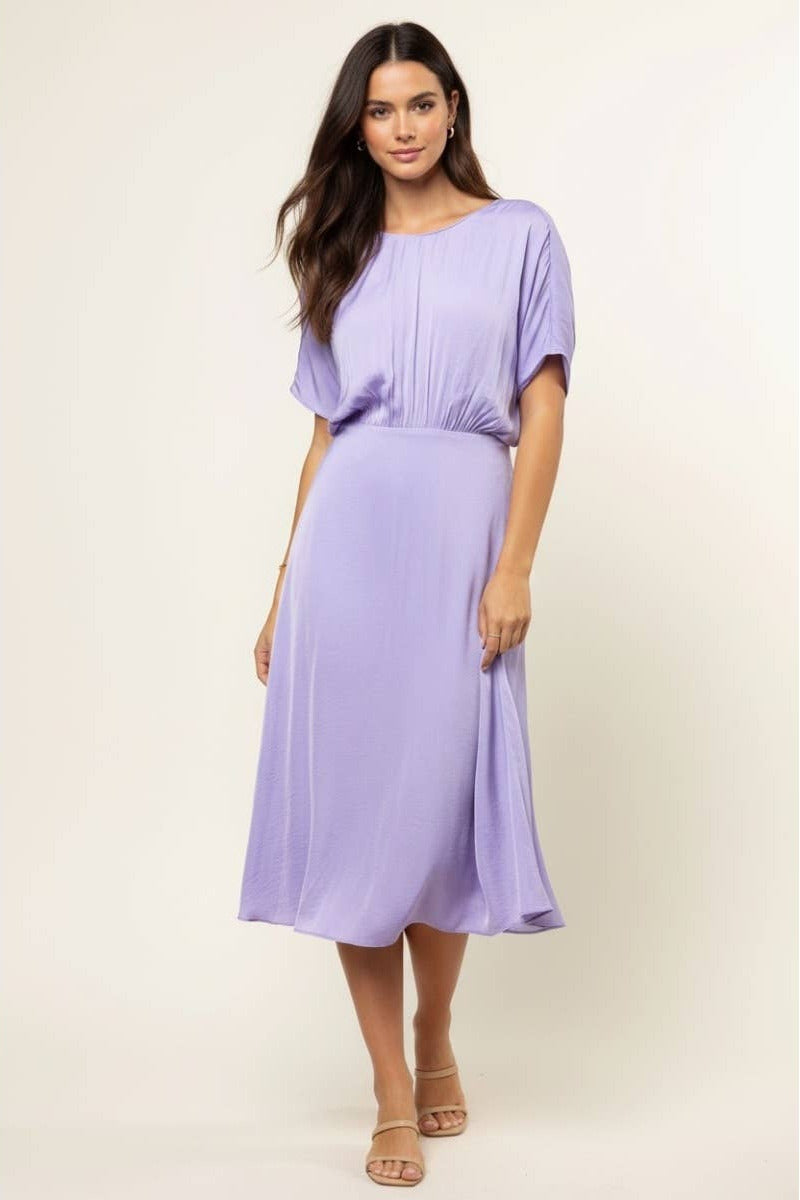 Woman wearing a light purple dress on a beige background