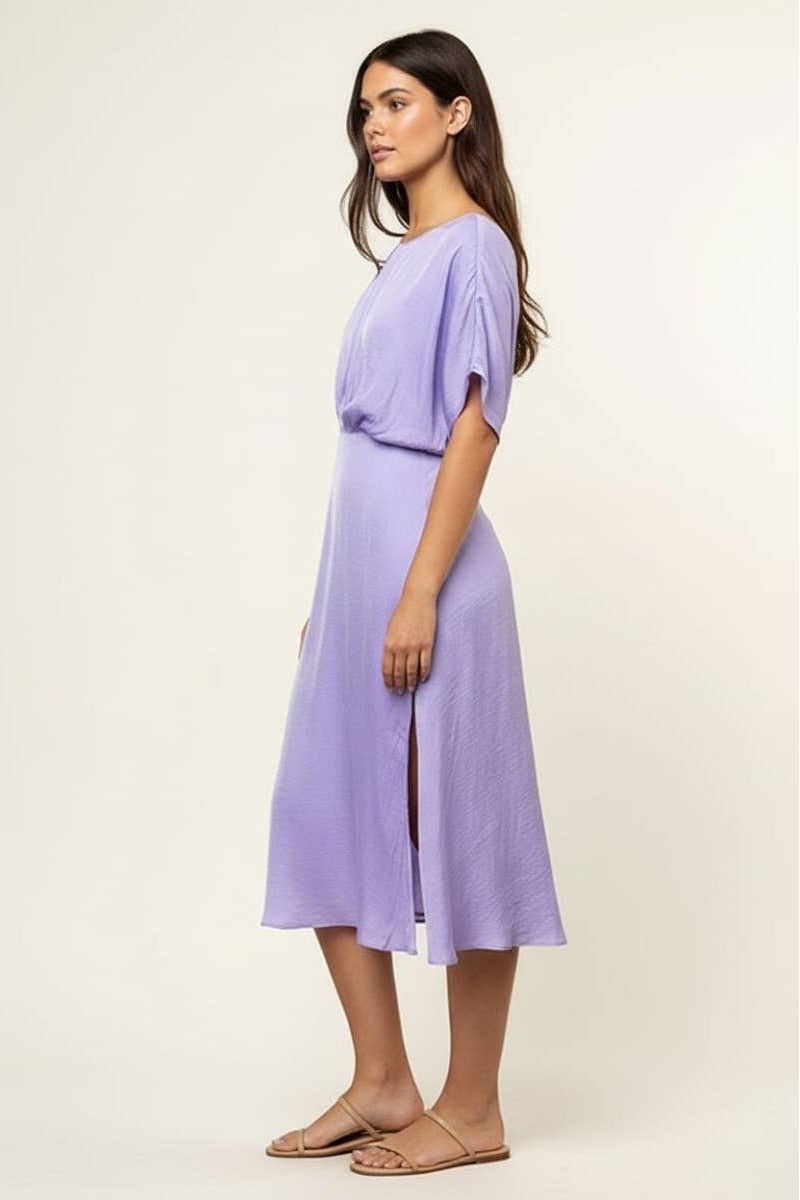 Woman wearing a light purple dress on a plain background