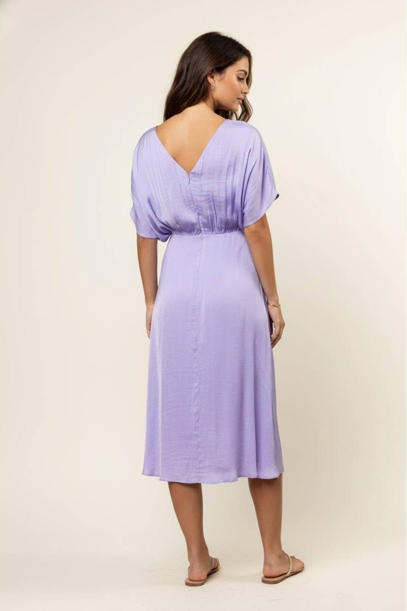 Woman wearing a light purple dress against a beige background