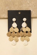 Pair of gold and beige chandelier earrings on a black card against a beige background