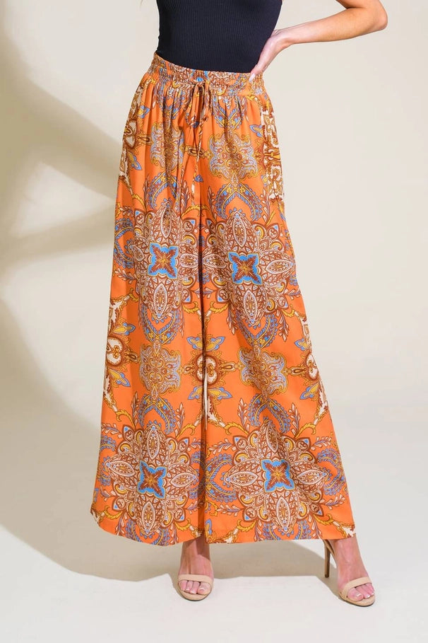 Orange patterned skirt worn by a person on a plain background