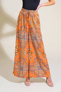 Orange patterned skirt worn by a person on a plain background