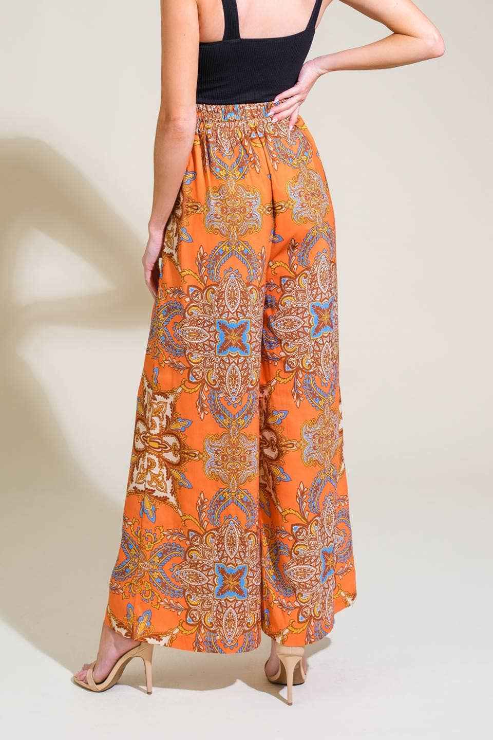 Orange patterned pants worn by a person on a plain background