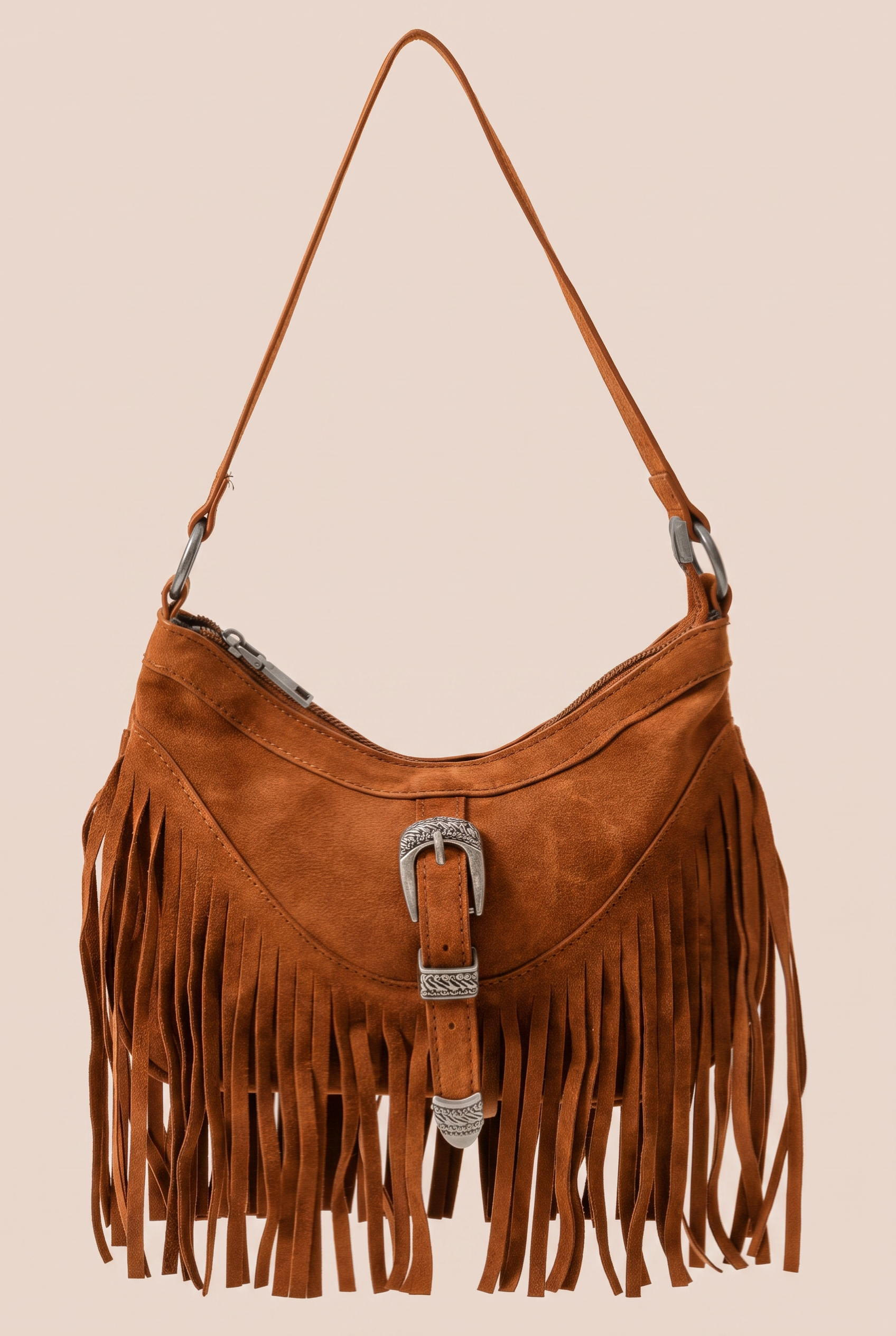 Brown suede handbag with fringe and a buckle on a beige background