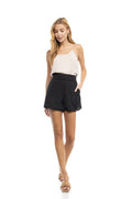 Woman wearing a white top and black shorts on a white background