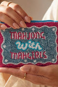 Hand holding a beaded pouch with 'Mahjong with Maggiris' text