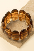 Brown beaded bracelet on a textured beige surface