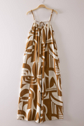 Brown and white patterned dress on a hanger against a white background