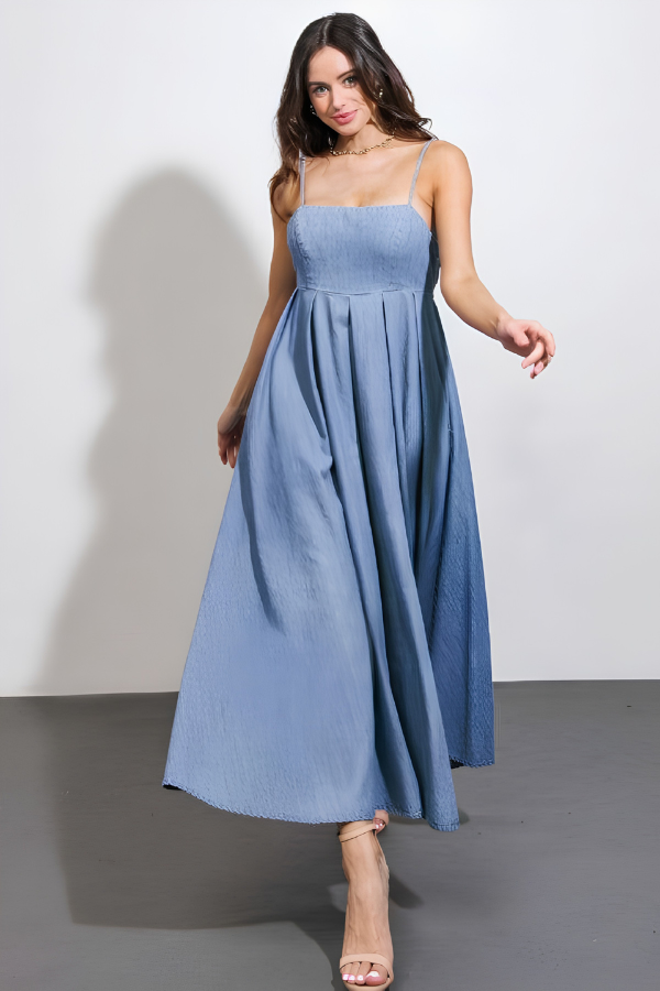 Woman wearing a blue dress against a plain background