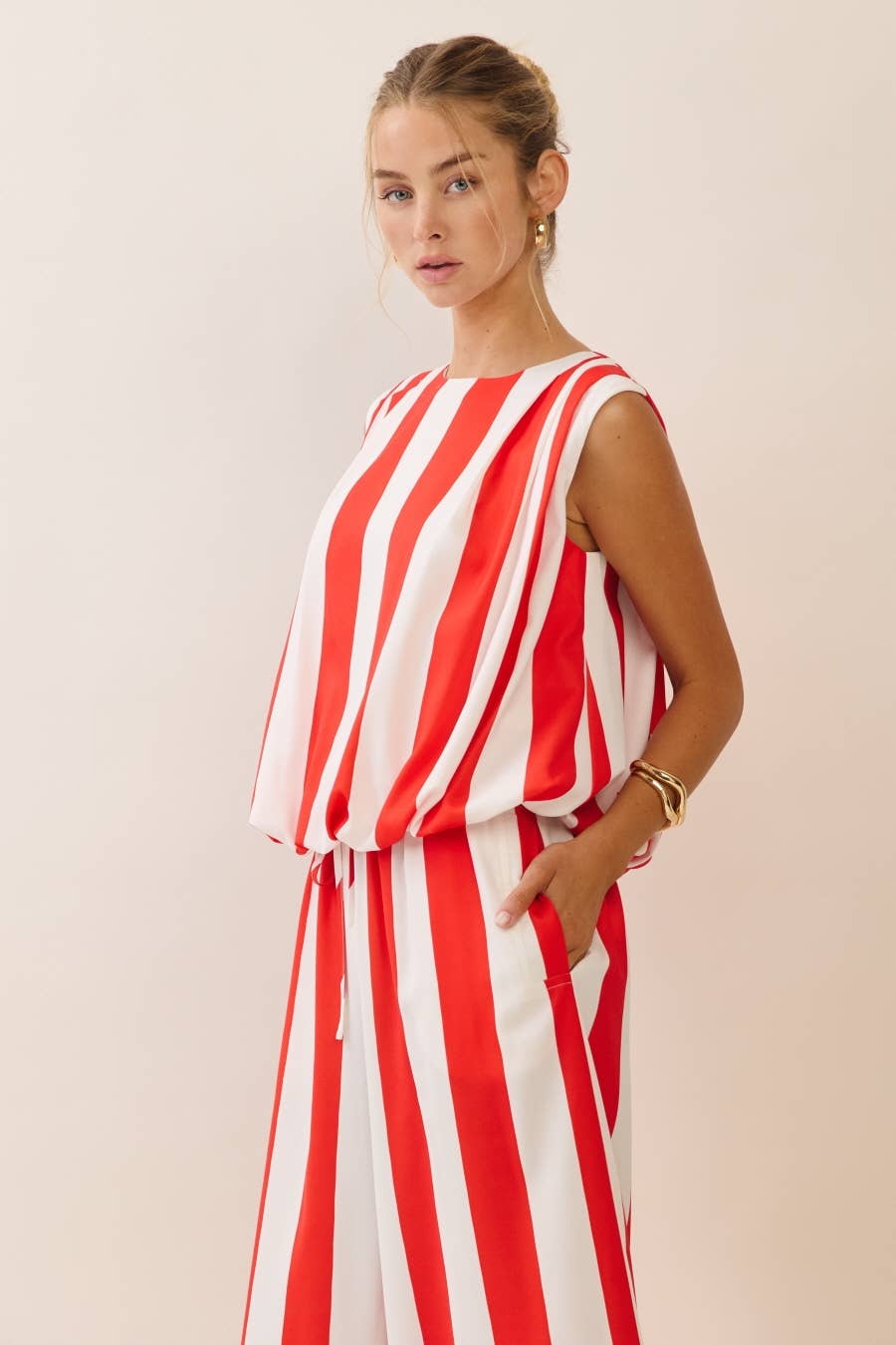 Woman wearing a red and white striped dress against a plain background