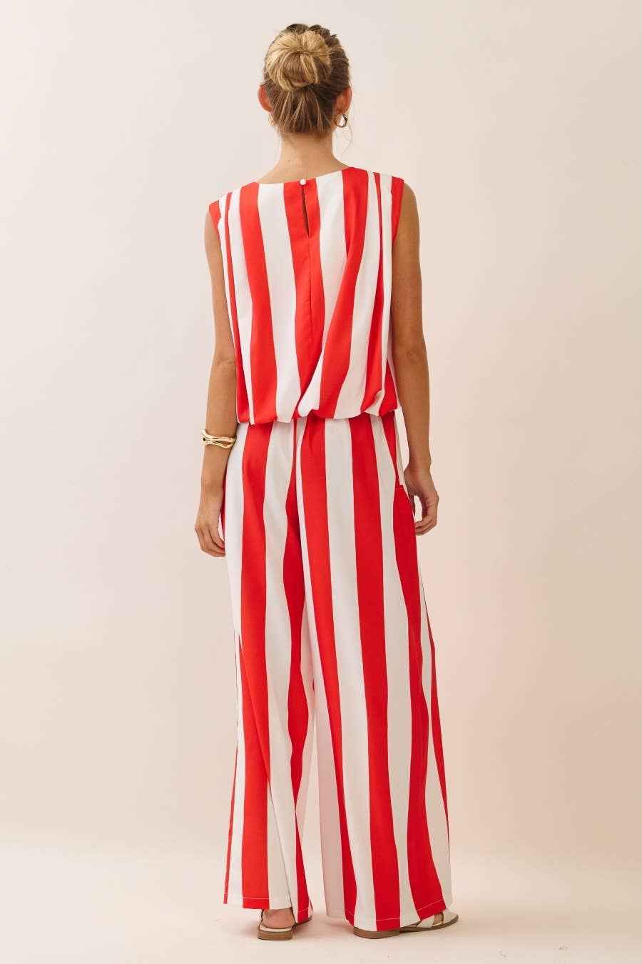 Woman wearing a red and white striped dress against a plain background