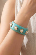 Turquoise bracelet with pearl-like embellishments on a wrist