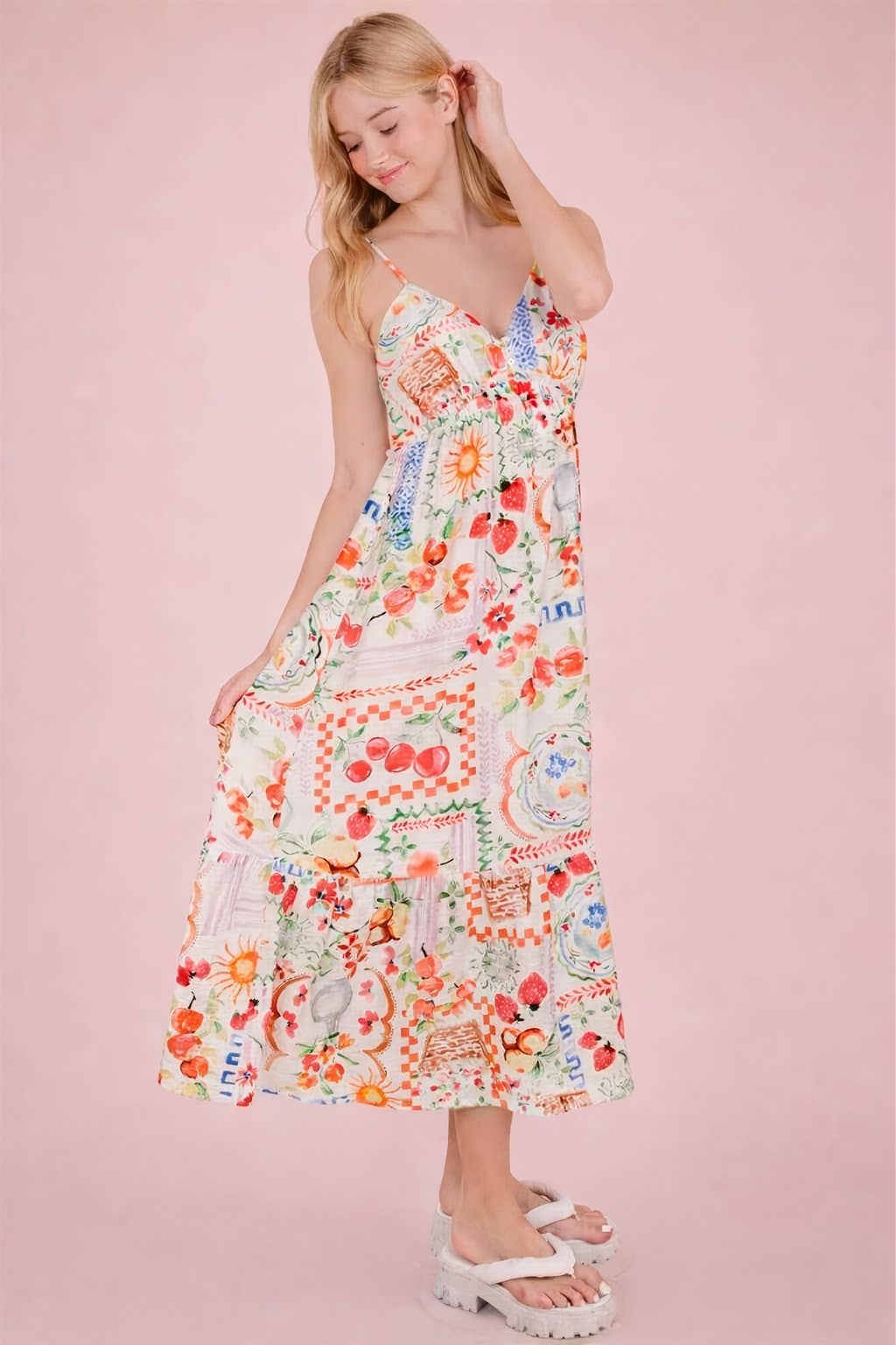 Woman wearing a colorful floral dress against a pink background