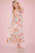 Woman wearing a colorful floral dress against a pink background