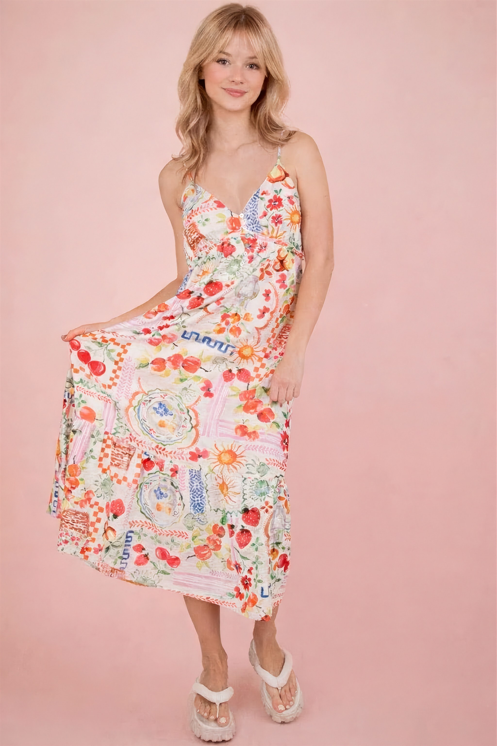 Woman wearing a colorful floral dress on a pink background