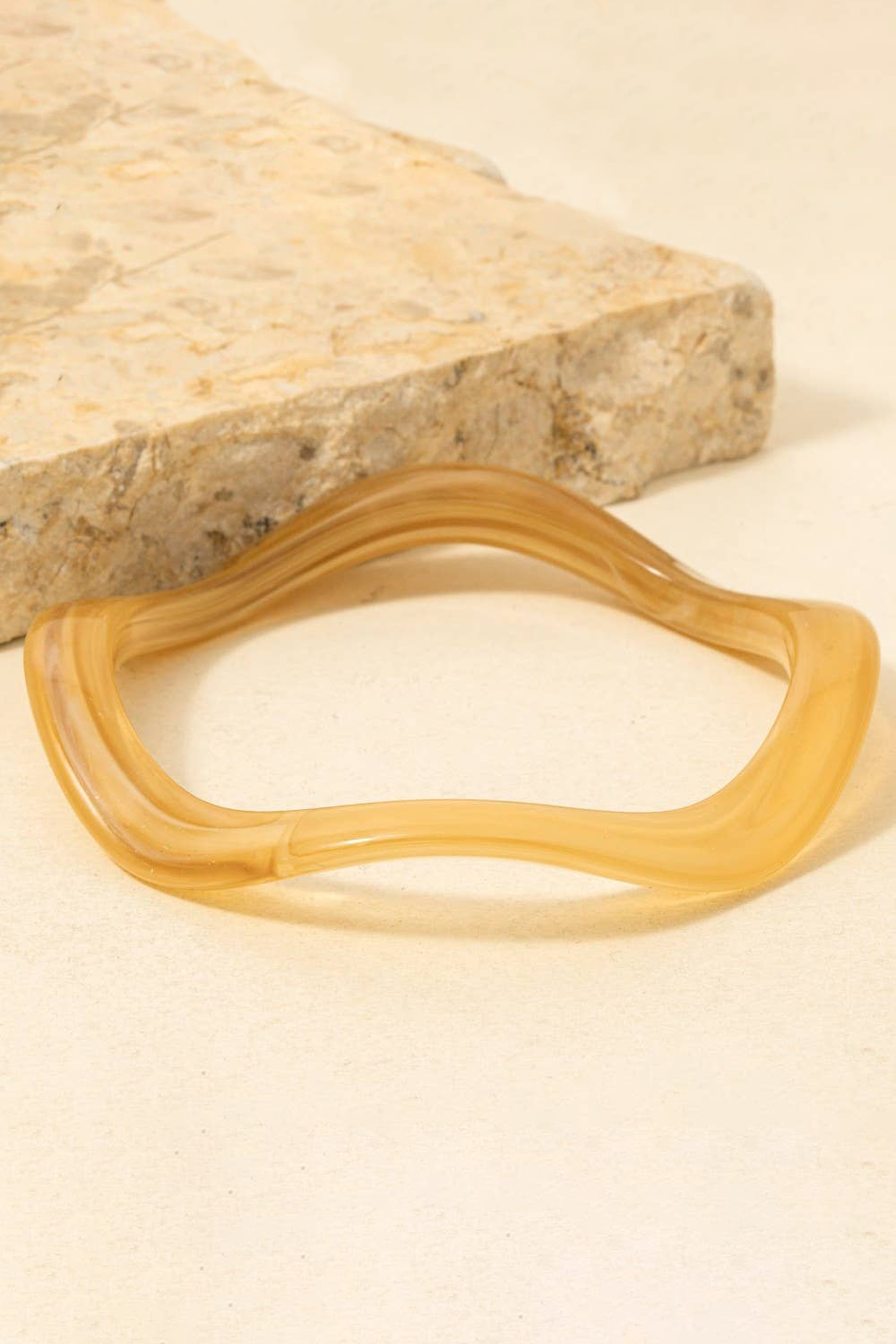 Yellow rubber band on a beige stone surface